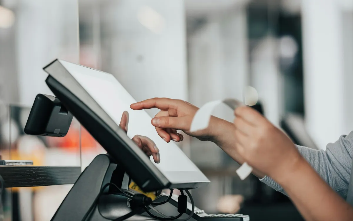 Dokunmatik self-servis ödeme terminalini kullanan bir kişinin elleri