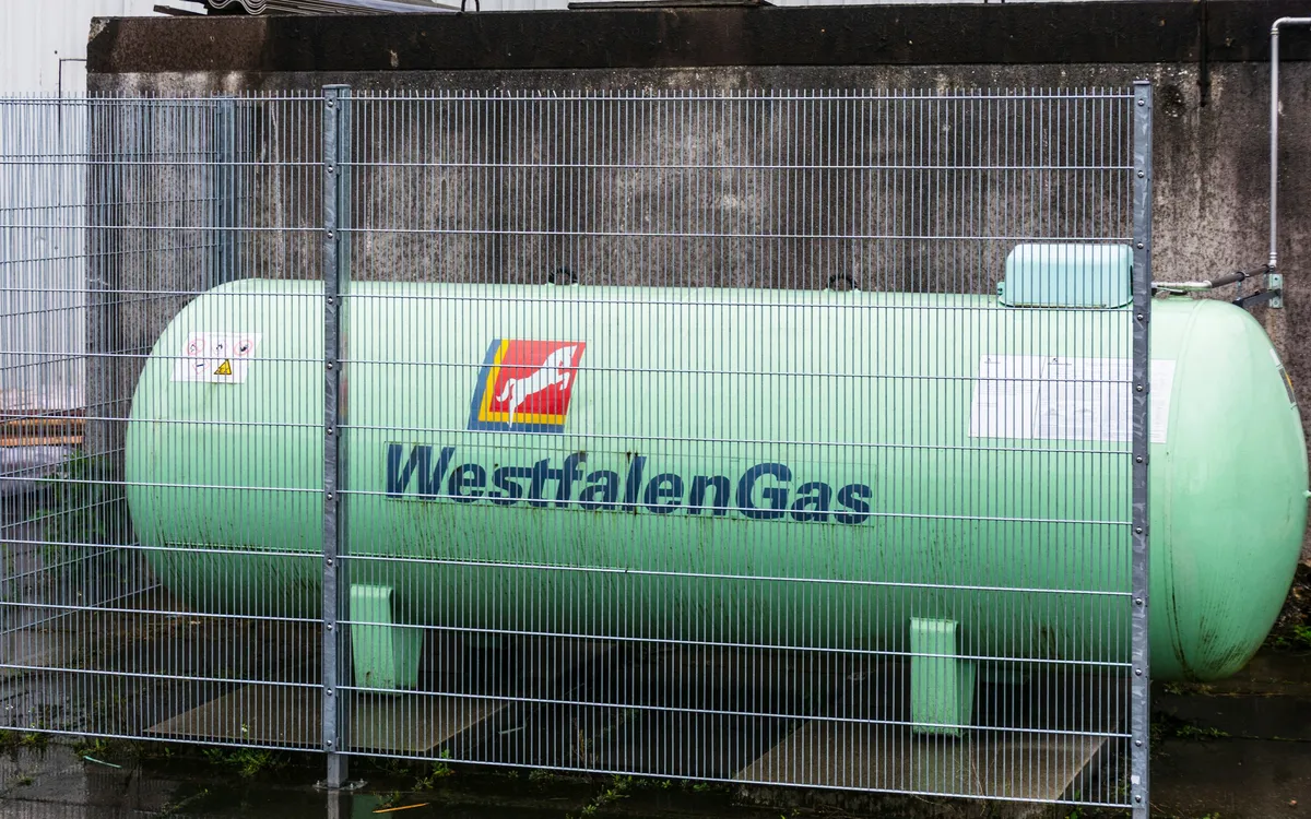 Tel örgü arkasında duran büyük yeşil gaz depolama tankı
